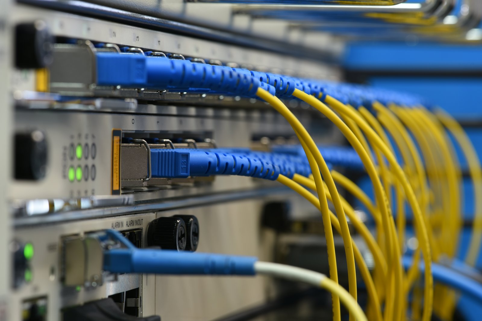 FTTH fiber optic infrastructure — patch panel with blue and yellow fiber cables